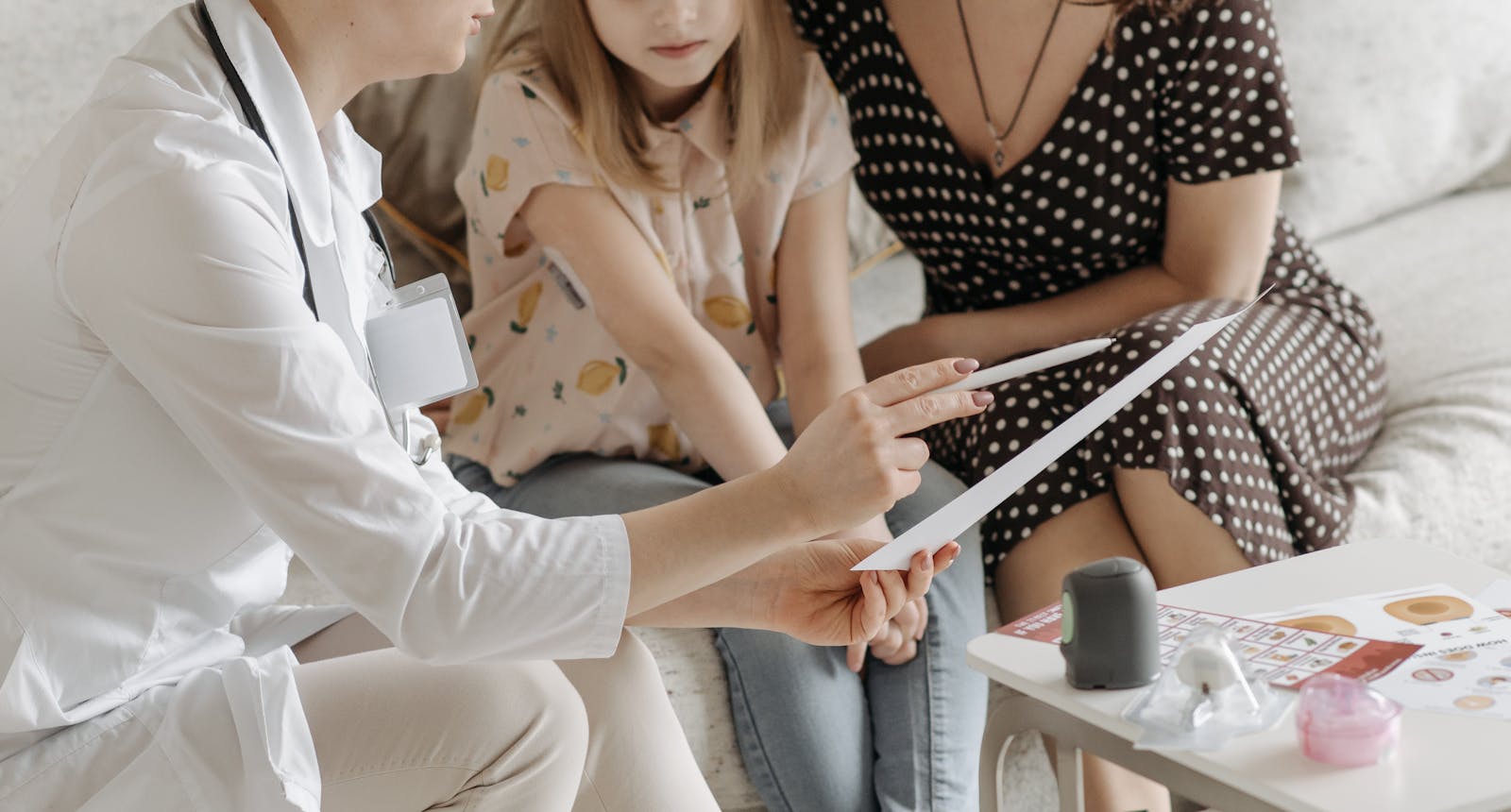 Ärztin im Gespräch mit einer Mutter und ihrem Kind